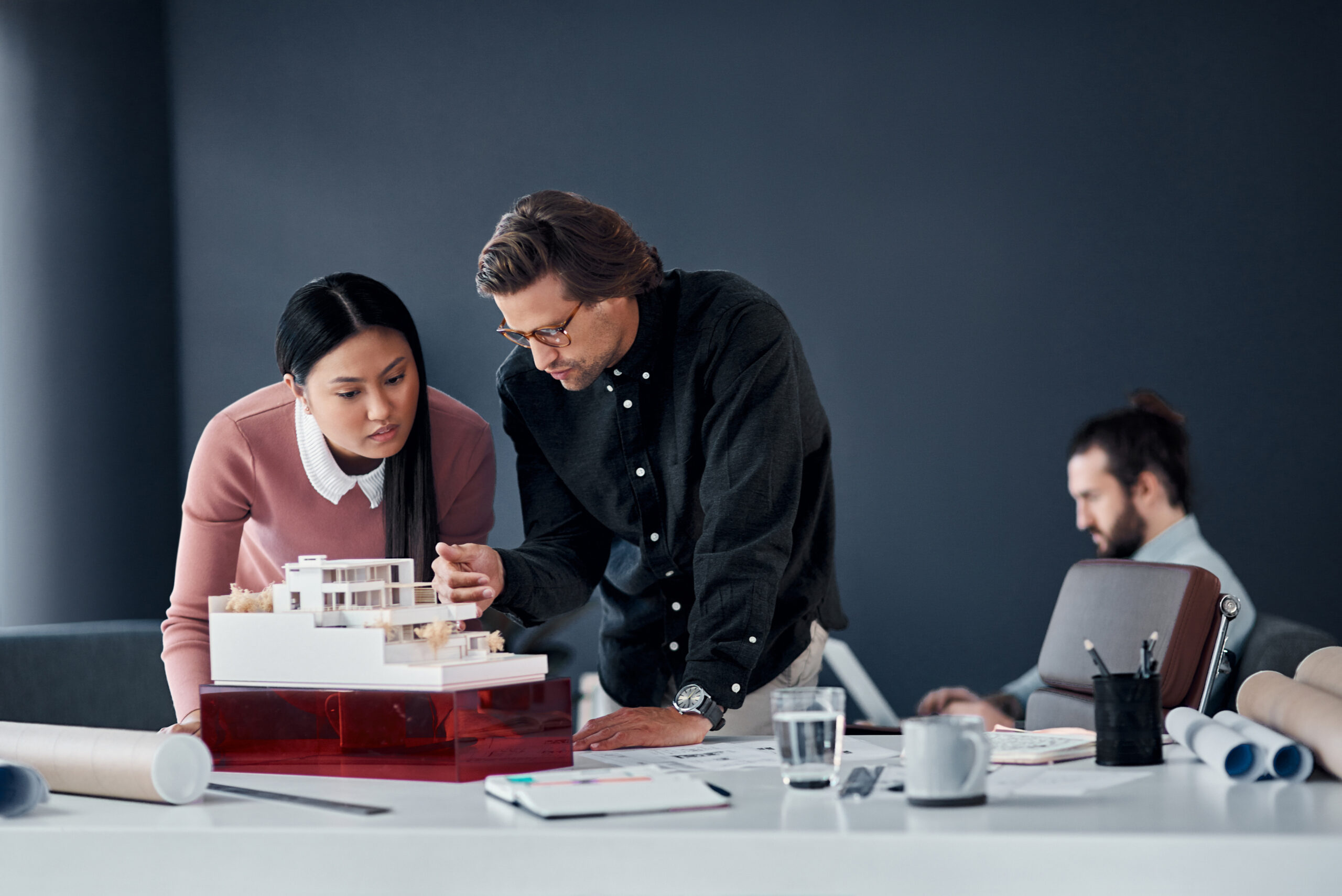 Business people, model and architecture with planning, brainstorming and building renovation ideas. Staff, engineering team and coworkers with cooperation or meeting for industrial project design.